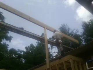 Carpenter setting a ridge beam over a new addition frame — Ice Dam Removal by Roofing Brothers in Hooksett