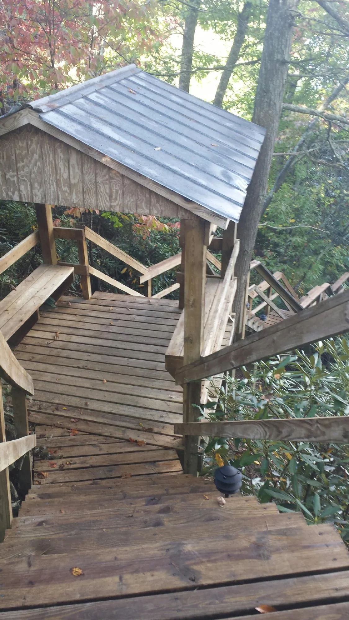 Metal roofed shelter over wooden steps on a wooded walkway — Skylight Repair & Installation work by our crew in Hooksett